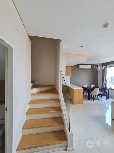 คอนโด ขายในRatchathewi, Bangkok - บันไดไม้ราวกระจกขึ้นสู่ชั้นบนข้างครัวเปิด