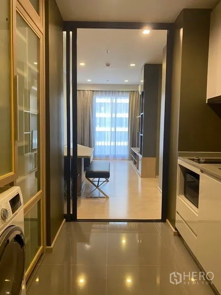คอนโด ให้เช่าในWatthana, Bangkok - โถงทางเดินพร้อมประตูกระจกบานเลื่อนเปิดสู่ห้องนั่งเล่นสว่างและผ้าม่านระเบียง พร้อมชั้นบิวท์อิน