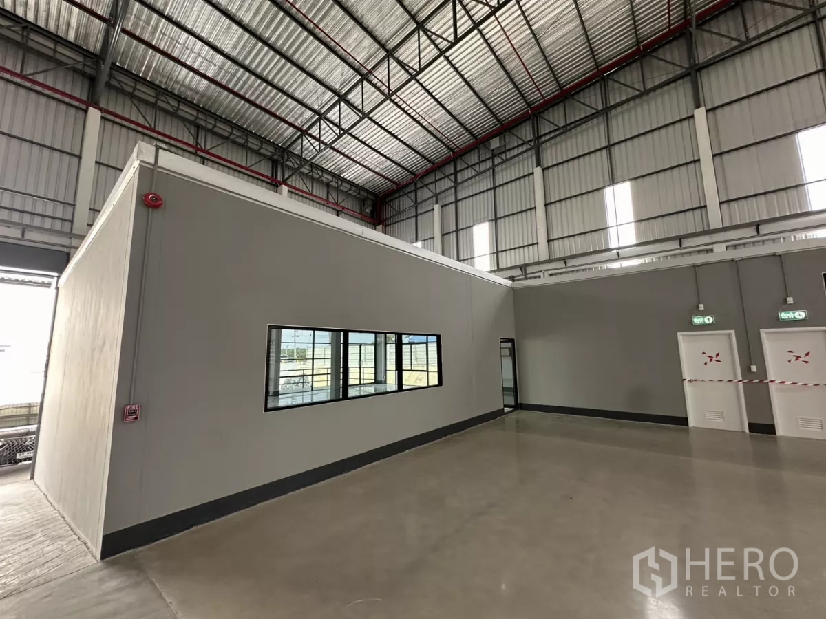 Factory for rent in Chon Buri - Internal office block with windows, emergency exit doors and fire safety fittings inside the factory.