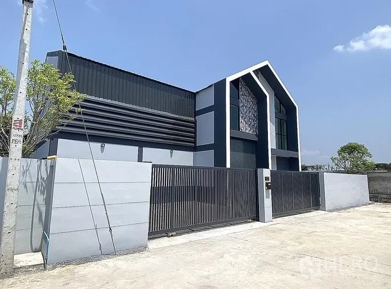 Warehouse for rent in Lat Lum Kaeo, Pathum Thani - Street‑side view of the secure front gate and contemporary warehouse facade.
