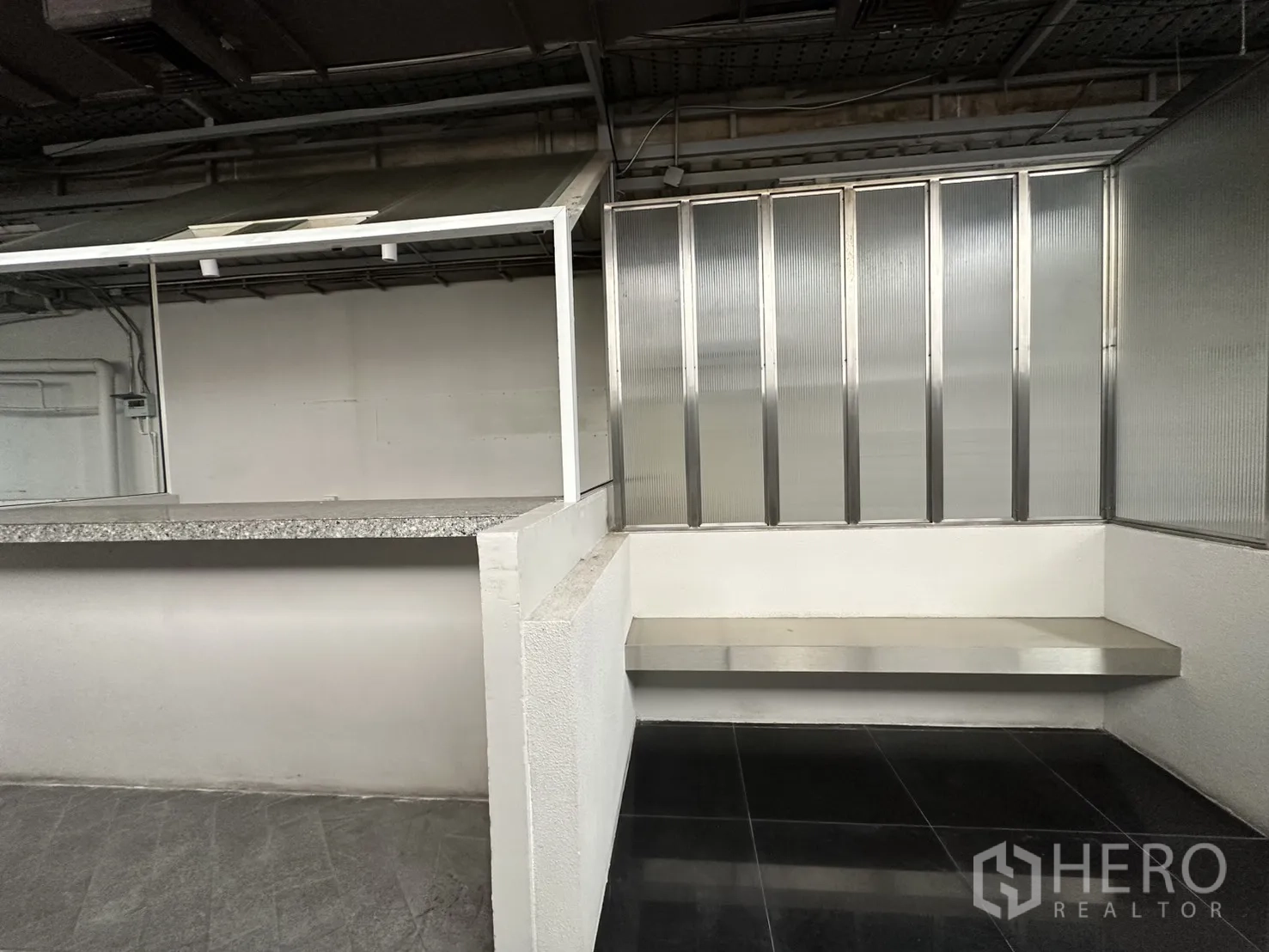 零售空间 for rent in Bang Rak, Bangkok - 转角内置长椅，旁有半透明高隔和石面服务台。