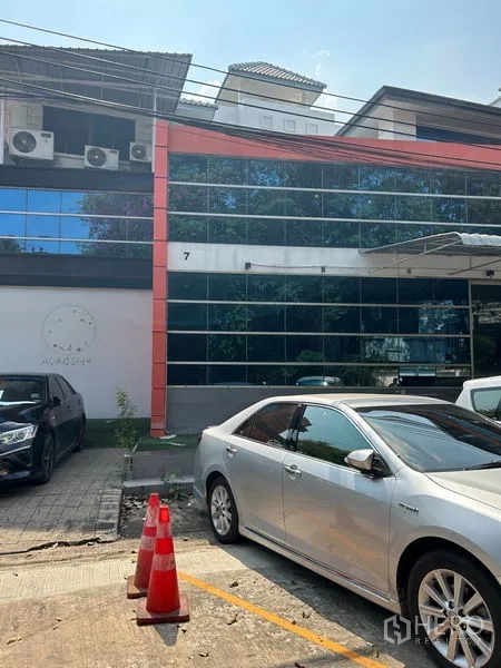 พื้นที่ขายปลีก ให้เช่าในWang Thonglang, Bangkok - อาคารค้าปลีกสองชั้นหน้ากระจกสะท้อน มีที่จอดรถและกรวยจราจรด้านหน้า