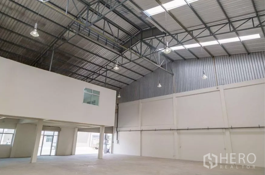 工厂 出租在Phra Samut Chedi, Samut Prakan - 高挑仓库内部，钢结构屋顶、天窗与吊灯