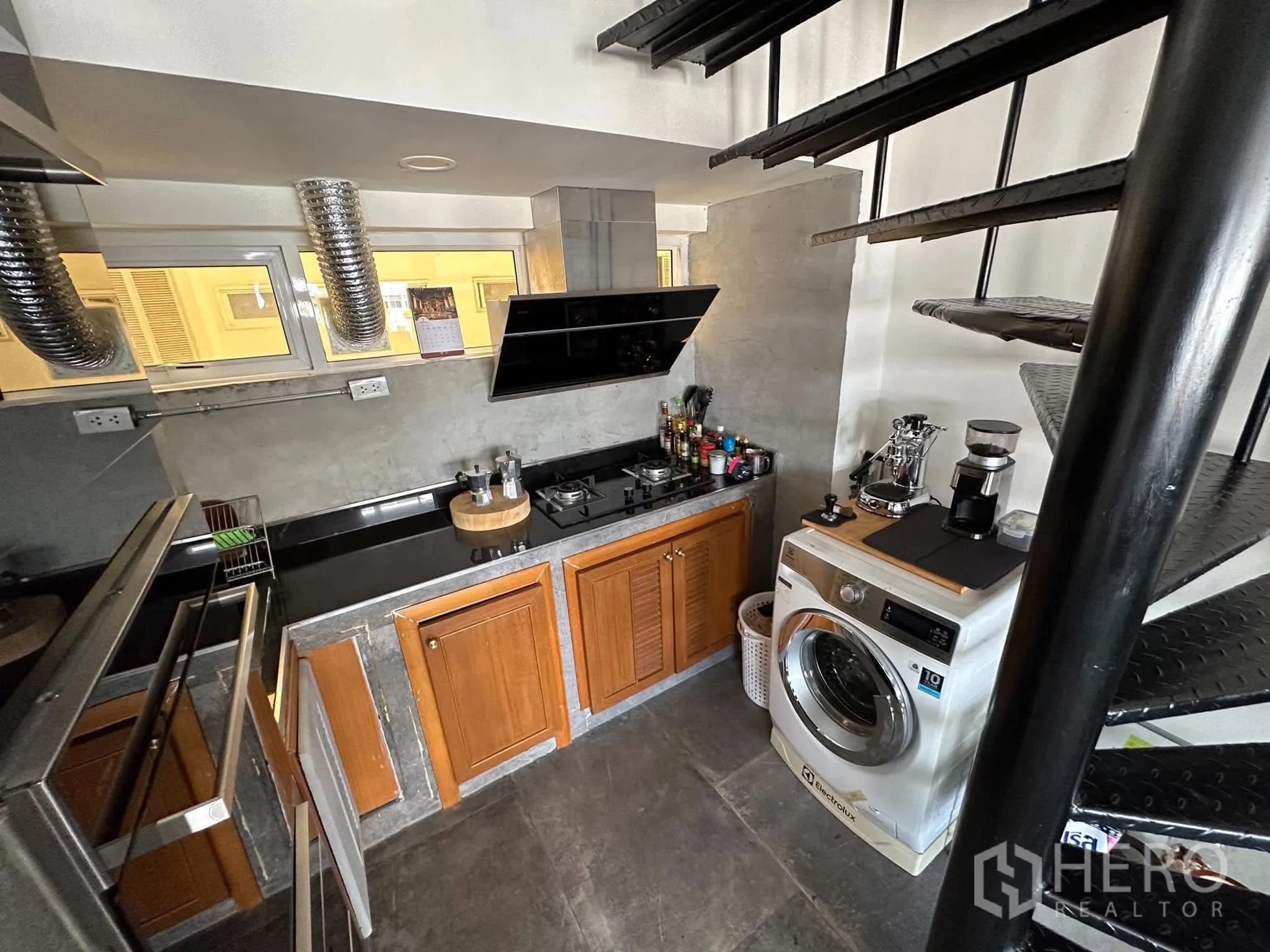 คอนโด ให้เช่าในWatthana, Bangkok - มุมครัวพร้อมเตาแก๊ส เครื่องซักผ้า และบันไดเวียนโลหะด้านบน