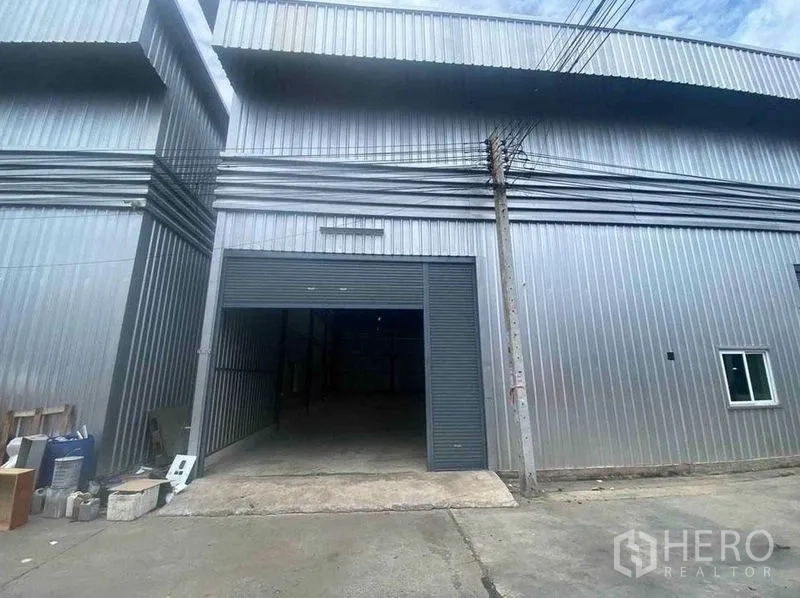 Warehouse for rent in Bang Phli, Samut Prakan - Front view of a steel-clad warehouse in Bang Phli with a wide roller shutter entrance.