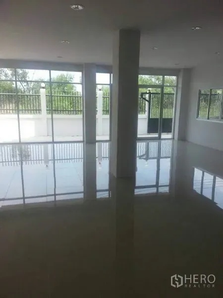 Factory for rent or sale in Khlong Luang, Pathum Thani - Bright office floor with glossy tiles and full-height windows overlooking the fenced yard.