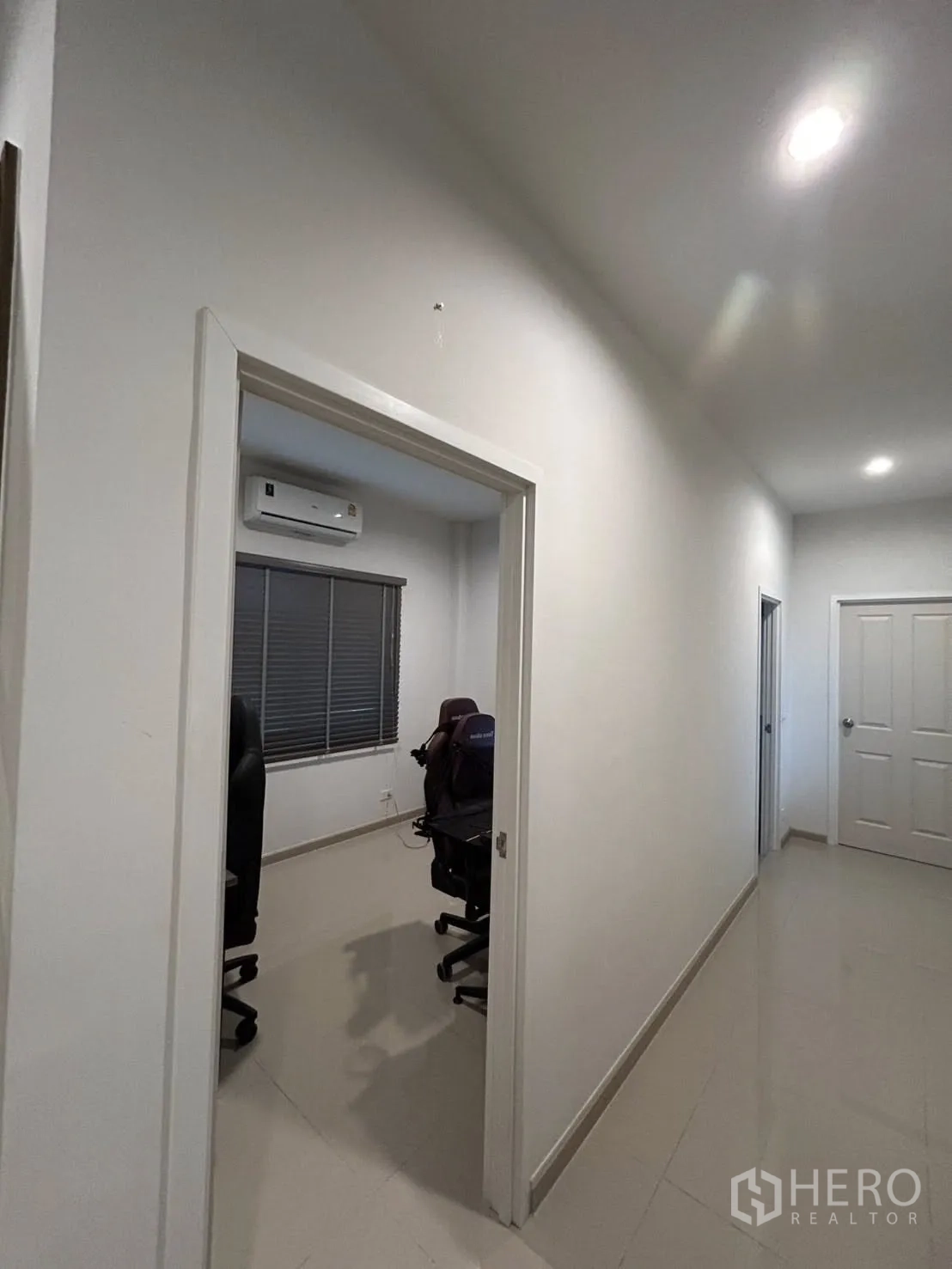 Detached House for rent in Khlong Sam Wa, Bangkok - Ground-floor multipurpose room set up as a workspace with air-conditioning.