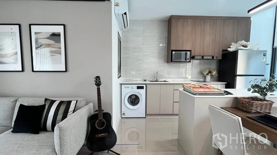 Townhouse for rent or sale in Bang Phli, Samut Prakan - Kitchen close‑up showing tall cabinets, island and window blind.