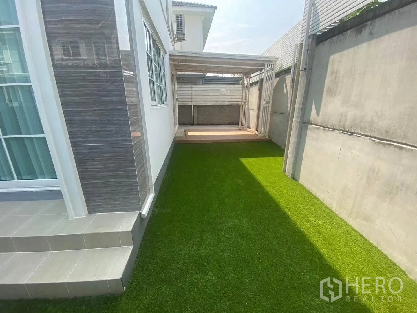 Detached House for rent in Mueang Samut Prakan, Samut Prakan - Green lawn beside the house leading to a covered deck.