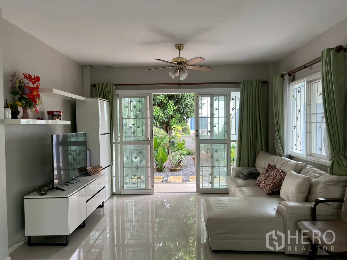 บ้าน ขายในMin Buri, Bangkok - ห้องนั่งเล่นเปิดออกสู่สวนด้วยประตูบานเลื่อนกระจก