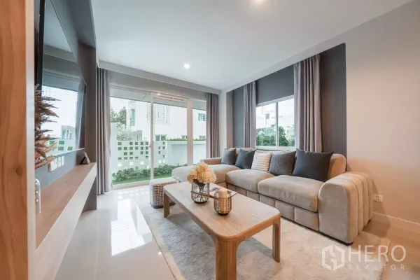 บ้าน ให้เช่าในSaphan Sung, Bangkok - ห้องนั่งเล่นสว่างโปร่ง โซฟารูปตัวแอล ประตูกระจกบานเลื่อนออกสู่สวนเล็ก