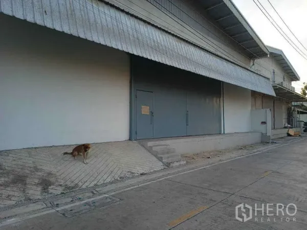 คลังสินค้า ให้เช่าในBang Phli, Samut Prakan - ด้านหน้าโกดังพร้อมโหลดดิ้งเบย์ กันสาด และประตูเหล็กบานเลื่อน ติดถนนเข้า-ออกสะดวก