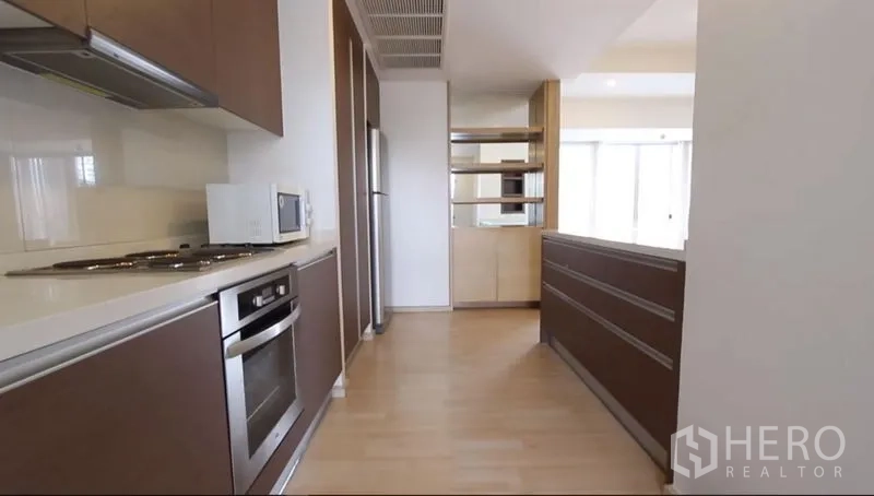 คอนโด ให้เช่าในWatthana, Bangkok - ครัวแบบแกลลีย์ เตาอบ เตาไฟฟ้า เครื่องดูดควัน ไมโครเวฟ และตู้สูง