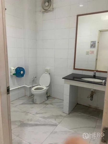 Office Space for rent in Saphan Sung, Bangkok - Tiled bathroom with toilet, sink, and wall mirror