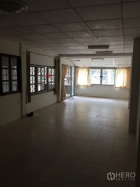 ทาวน์เฮาส์ ให้เช่าในKhlong Toei, Bangkok - ห้องนั่งเล่นปูพื้นกระเบื้องยาว มีหน้าต่างผ้าม่านรับแสงธรรมชาติ