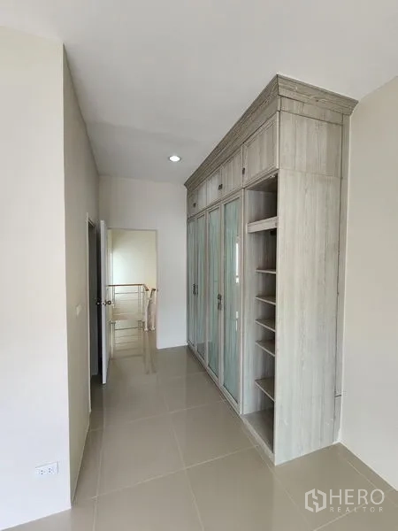 Townhouse for rent in Wang Thonglang, Bangkok - Hallway featuring a tall built-in wardrobe with shelving.