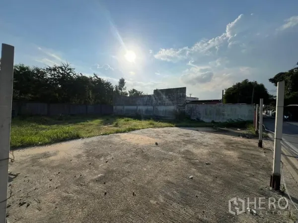 ที่ดิน ขายในBang Na, Bangkok - แปลงดินถมเรียบ มีพื้นคอนกรีตและกำแพงรอบ แดดบ่ายส่องบนพื้นที่หญ้า