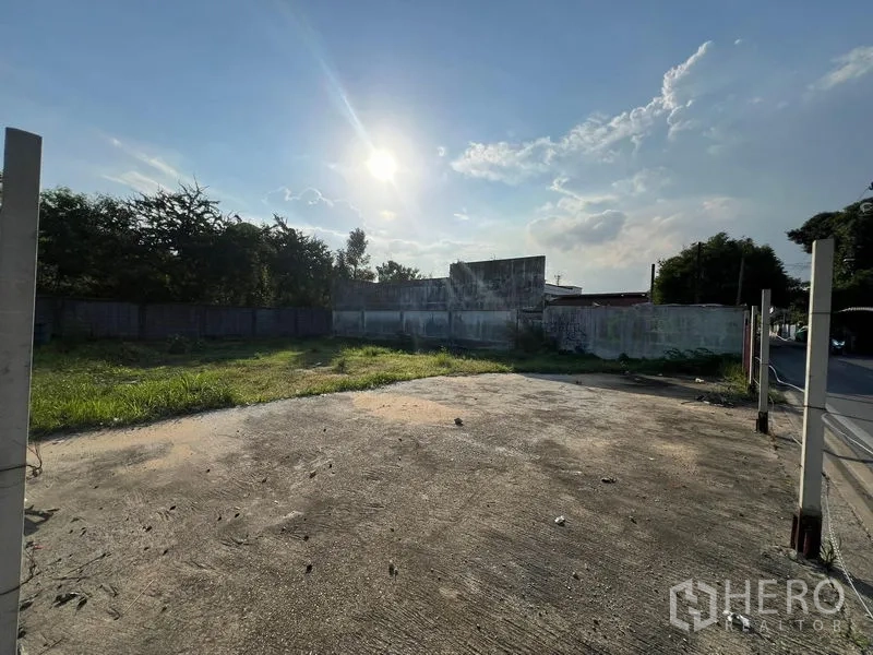 ที่ดิน ขายในBang Na, Bangkok - แปลงดินถมเรียบ มีพื้นคอนกรีตและกำแพงรอบ แดดบ่ายส่องบนพื้นที่หญ้า