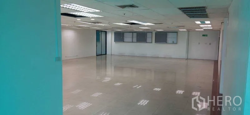 办公空间 出租在Huai Khwang, Bangkok - 反向视角的明亮办公空间，带空调出风口、白色墙面与出入口。