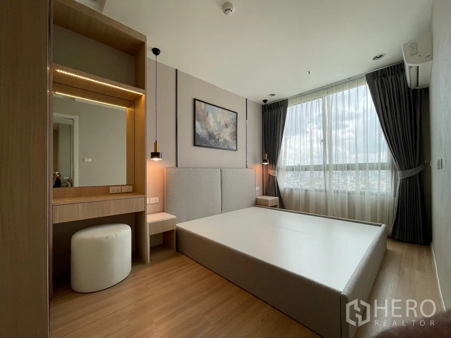 คอนโด for rent in Suan Luang, Bangkok - ห้องนอนหลักมีหน้าต่างบานใหญ่ โต๊ะเครื่องแป้ง โคมไฟแขวน และวิวเมือง