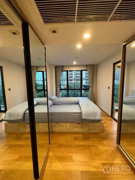 公寓 出租在Pathum Wan, Bangkok - 主卧带镜面衣柜、木地板与观景窗。