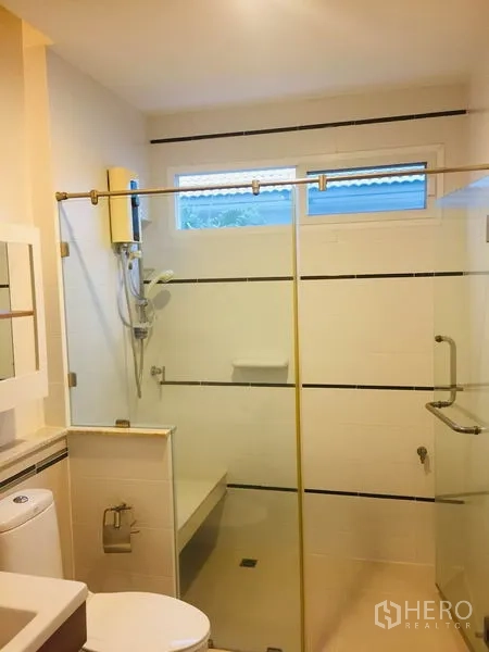 Detached House for rent in Bang Kapi, Bangkok - Modern bathroom with glass-enclosed shower, built-in bench and water heater.