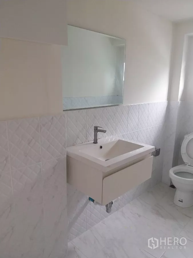 พื้นที่ขายปลีก ให้เช่า - ห้องน้ำปูกระเบื้องสีขาว สะอาด พร้อมอ่างล้างหน้า กระจก และโถสุขภัณฑ์