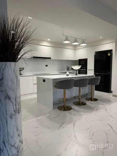 Detached House for rent in Suan Luang, Bangkok - Sleek white kitchen with island, pendant lights and bar stools.