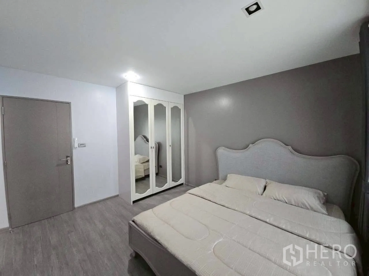 ทาวน์เฮาส์ ให้เช่าหรือขายในLat Phrao, Bangkok - มุมห้องนอนเห็นตู้เสื้อผ้าบานกระจกเงา หัวเตียงบุผ้า โทนสีอบอุ่น