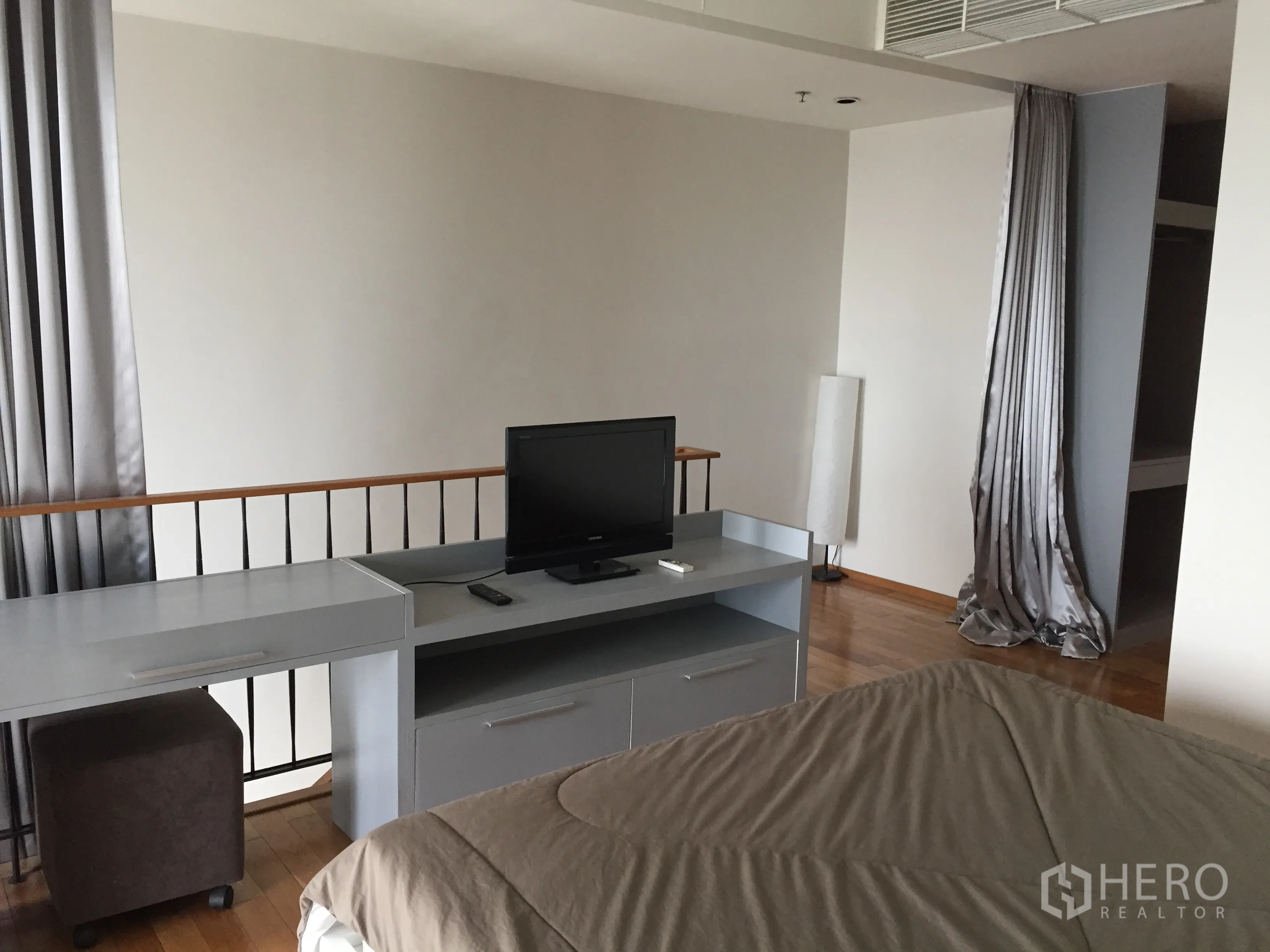 คอนโด ให้เช่าในKhlong Toei, Bangkok - ห้องนอนมีโต๊ะทำงาน ตู้วางทีวี และตู้เสื้อผ้าปิดผ้าม่าน พื้นไม้