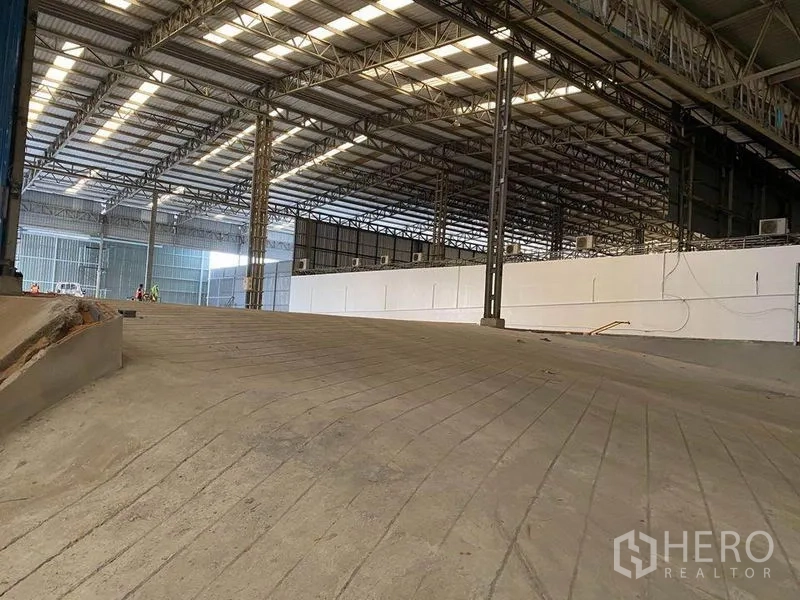 Factory for rent in Khlong Toei, Bangkok - Heavy-duty internal loading ramp inside the factory with steel columns and skylit roofing.