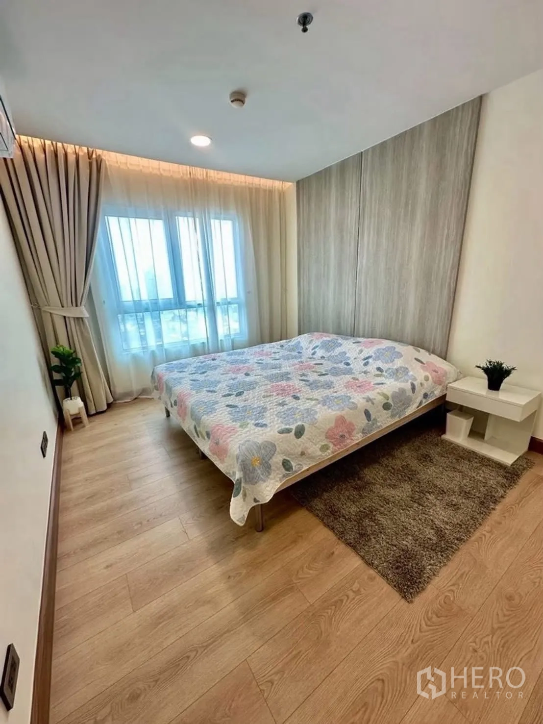 Condominium for rent in Huai Khwang, Bangkok - Bright second bedroom with large windows and wood floors.