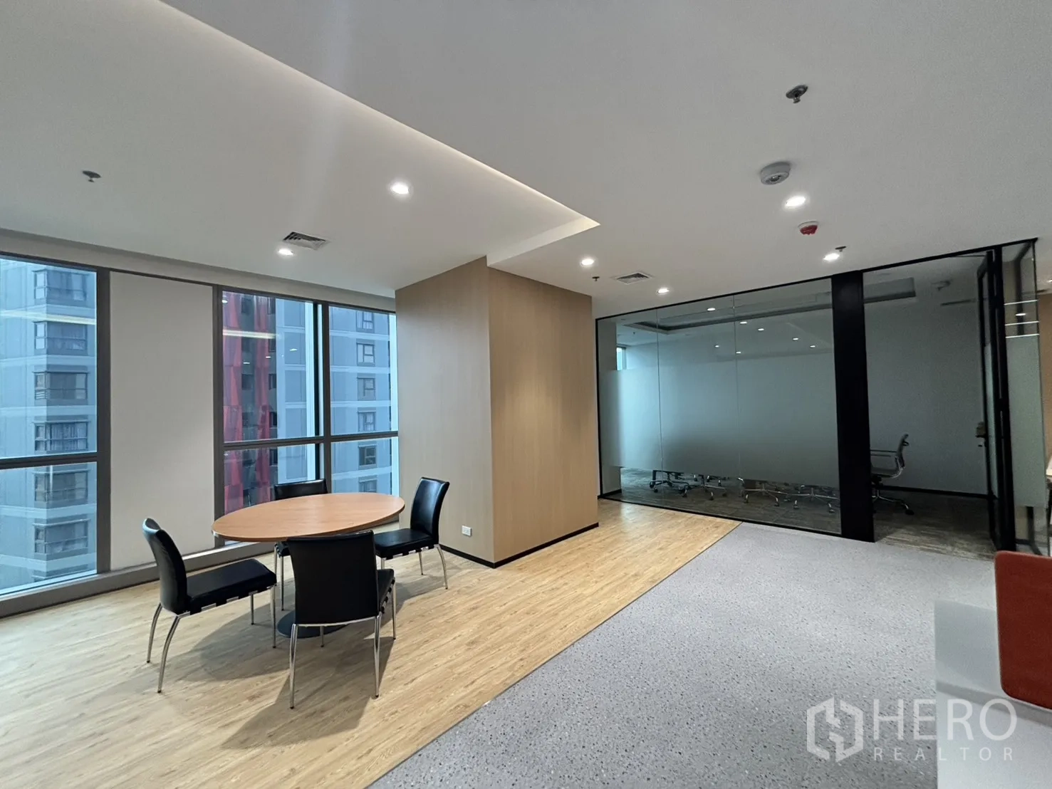 Office Space for rent in Huai Khwang, Bangkok - Round meeting table area next to a glass-walled conference room and large windows.