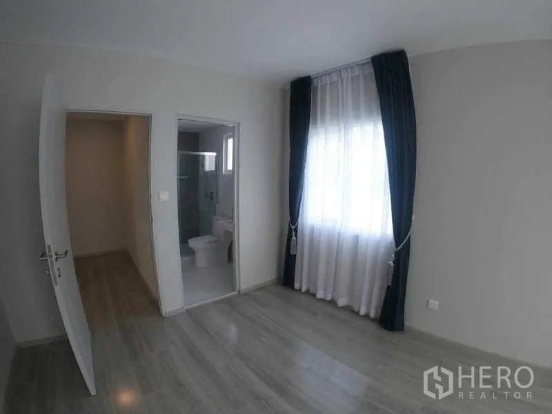 Townhouse for rent - Bedroom with large window, curtains, and ensuite bathroom with glass shower.