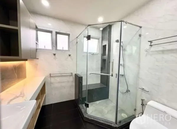 Detached House for rent in Phasi Charoen, Bangkok - Contemporary bathroom with glass shower enclosure and marble-effect walls.