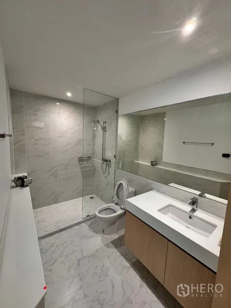 อพาร์ทเมนท์ ให้เช่าในKhlong Toei, Bangkok - ห้องน้ำโมเดิร์น พร้อมฝักบัวกระจกกั้น กระเบื้องลายหินอ่อน อ่างล้างหน้าใหญ่ และกระจกบานยาว