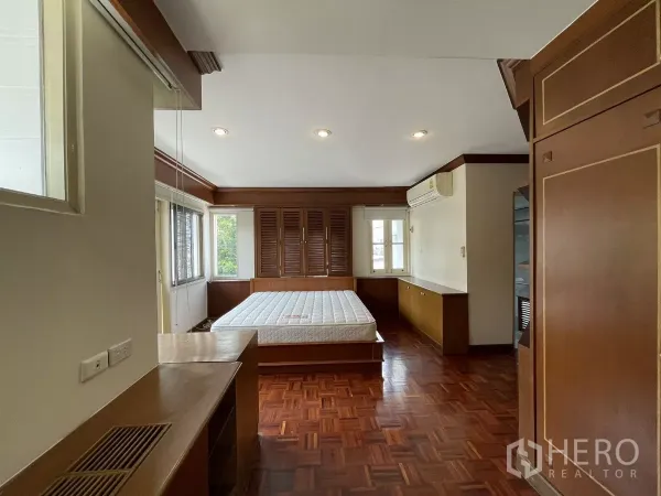 Detached House for rent in Chatuchak, Bangkok - Bright bedroom with built-in storage, air conditioner and parquet floor.