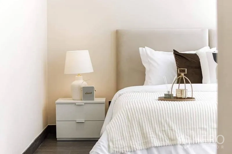 公寓 出租在Bang Rak, Bangkok - 床头柜配台灯与素雅床品，收纳有序。