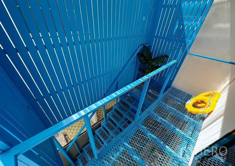 Home Office for rent in Watthana, Bangkok - View down a bright blue metal stairwell with slatted privacy panels.