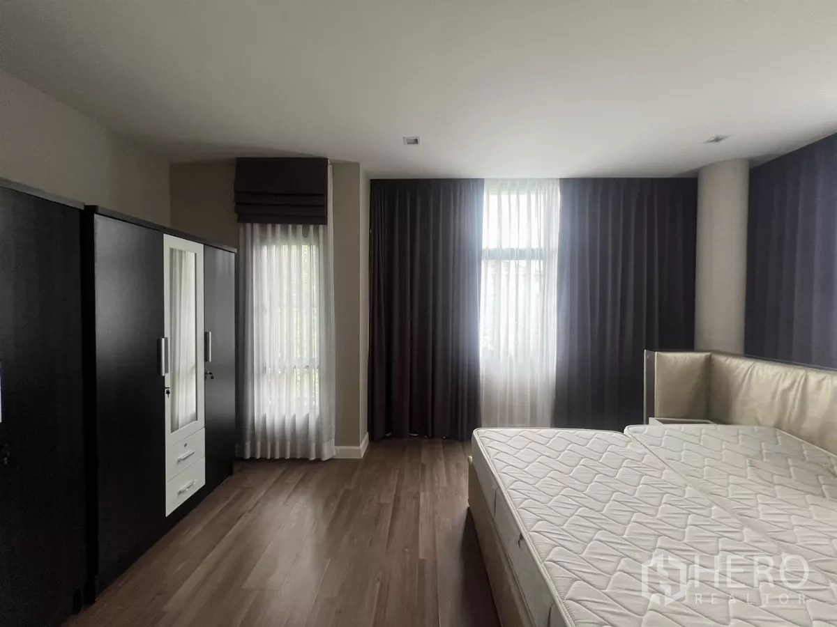 Detached House for sale in Bang Kapi, Bangkok - Master bedroom view showing wardrobes and multiple full-height windows.