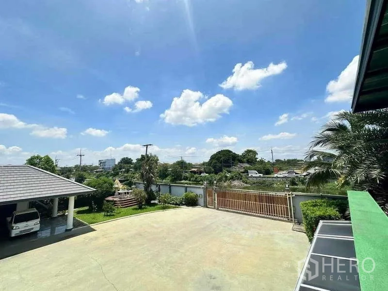 บ้าน ขายในKhlong Luang, Pathum Thani - มุมมองเหนือทางวิ่งรถไปยังประตูรั้ว คลอง และชุมชนโดยรอบ