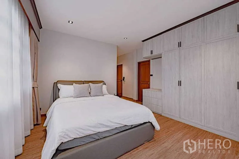 บ้าน ให้เช่าหรือขายในPhra Khanong, Bangkok - ห้องนอนพร้อมตู้เสื้อผ้าบิวท์อินสีขาวและเตียงควีน