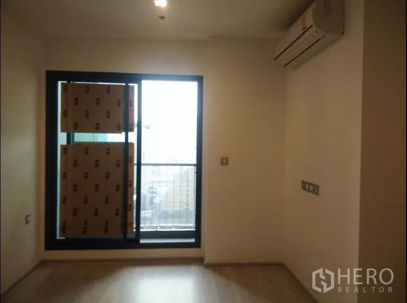 公寓 出售在Ratchathewi, Bangkok - 卧室配壁挂空调与通往阳台的推拉玻璃门