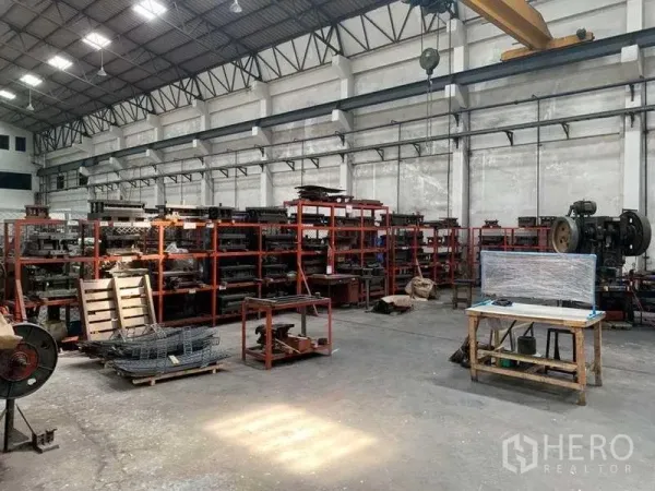 工厂 出租在Samut Prakan - 挑高生产车间，设有红色货架、工业设备与行车。