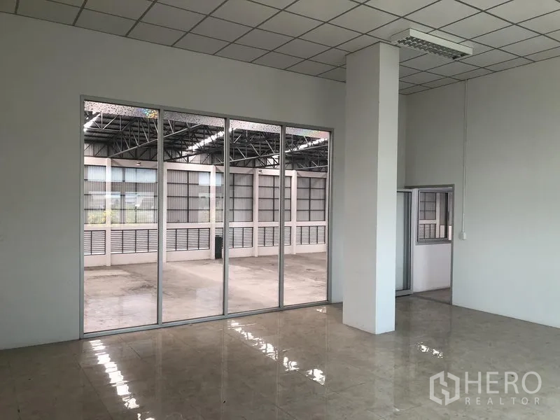 工厂 出租在Phra Nakhon Si Ayutthaya - 采光良好的瓷砖办公室，整面玻璃墙面对仓库。