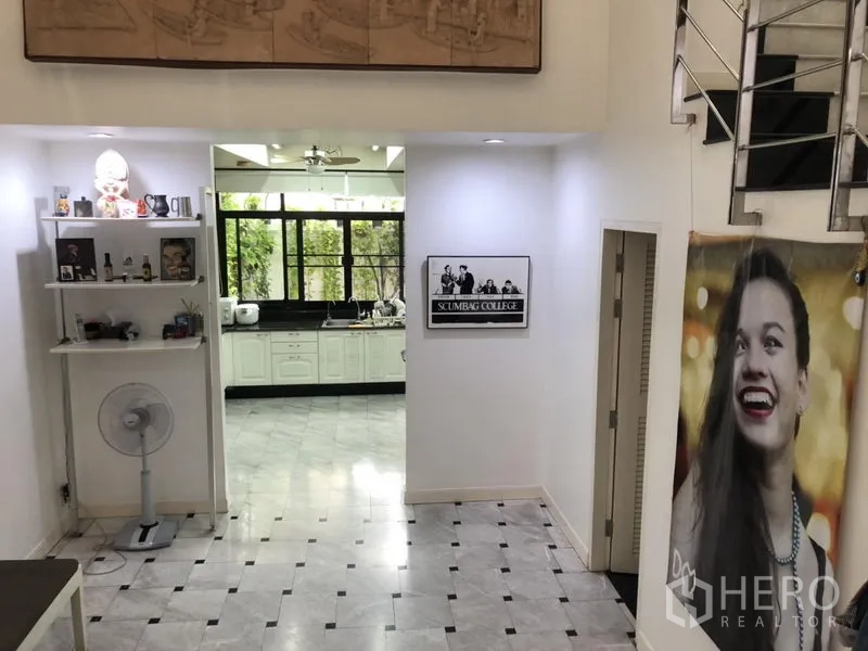 ทาวน์เฮาส์ ให้เช่าหรือขายในBangkok - โถงเปิดโล่งพื้นหินอ่อน เชื่อมสู่ครัว พร้อมชั้นวางของและราวบันไดโลหะ