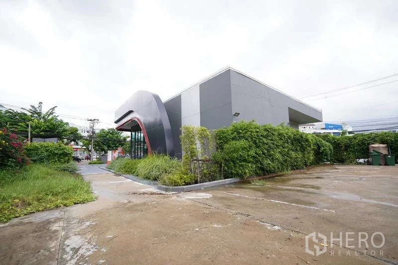 独立商业地产 出租在Bang Na, Bangkok - 现代曲线立面的独栋商业建筑，宽敞车道与停车区。