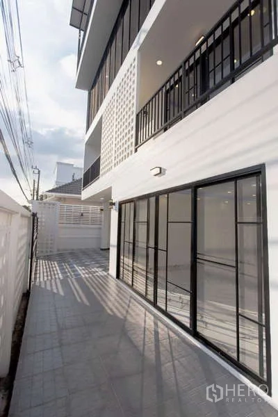 สำนักงานที่บ้าน ขายในHuai Khwang, Bangkok - ทางเดินด้านข้างอาคาร มีประตูกระจกบานเลื่อนและระเบียงชั้นบน