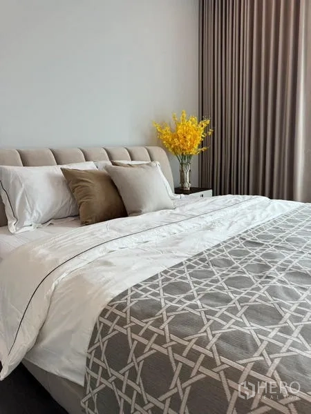 Detached House for rent or sale in Bang Kapi, Bangkok - Elegant bedroom with upholstered bed and neutral decor.