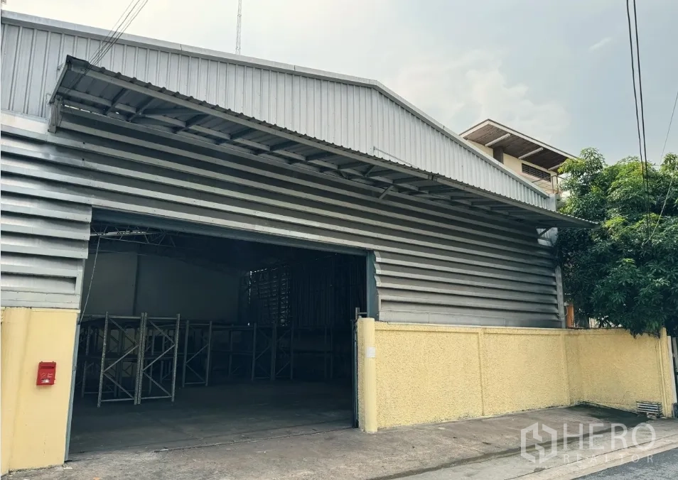 Warehouse for rent in Din Daeng, Bangkok - Angled exterior of the warehouse with open loading bay and covered awning for deliveries.